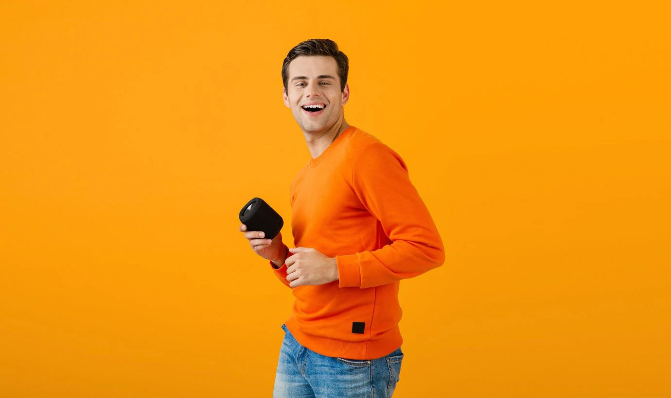 Stylish young man holding wireless speaker 2