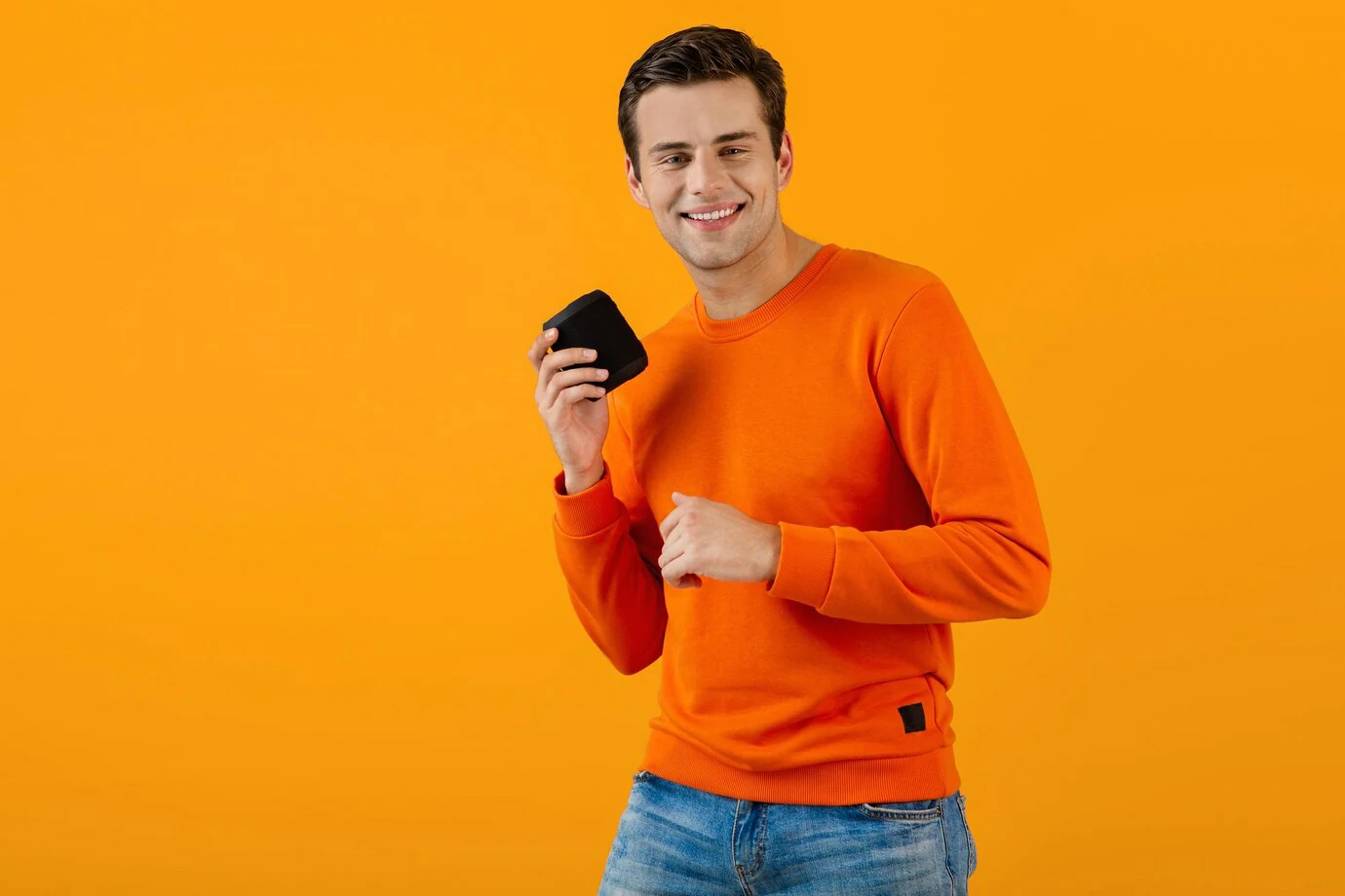 Stylish young man holding wireless speaker 3