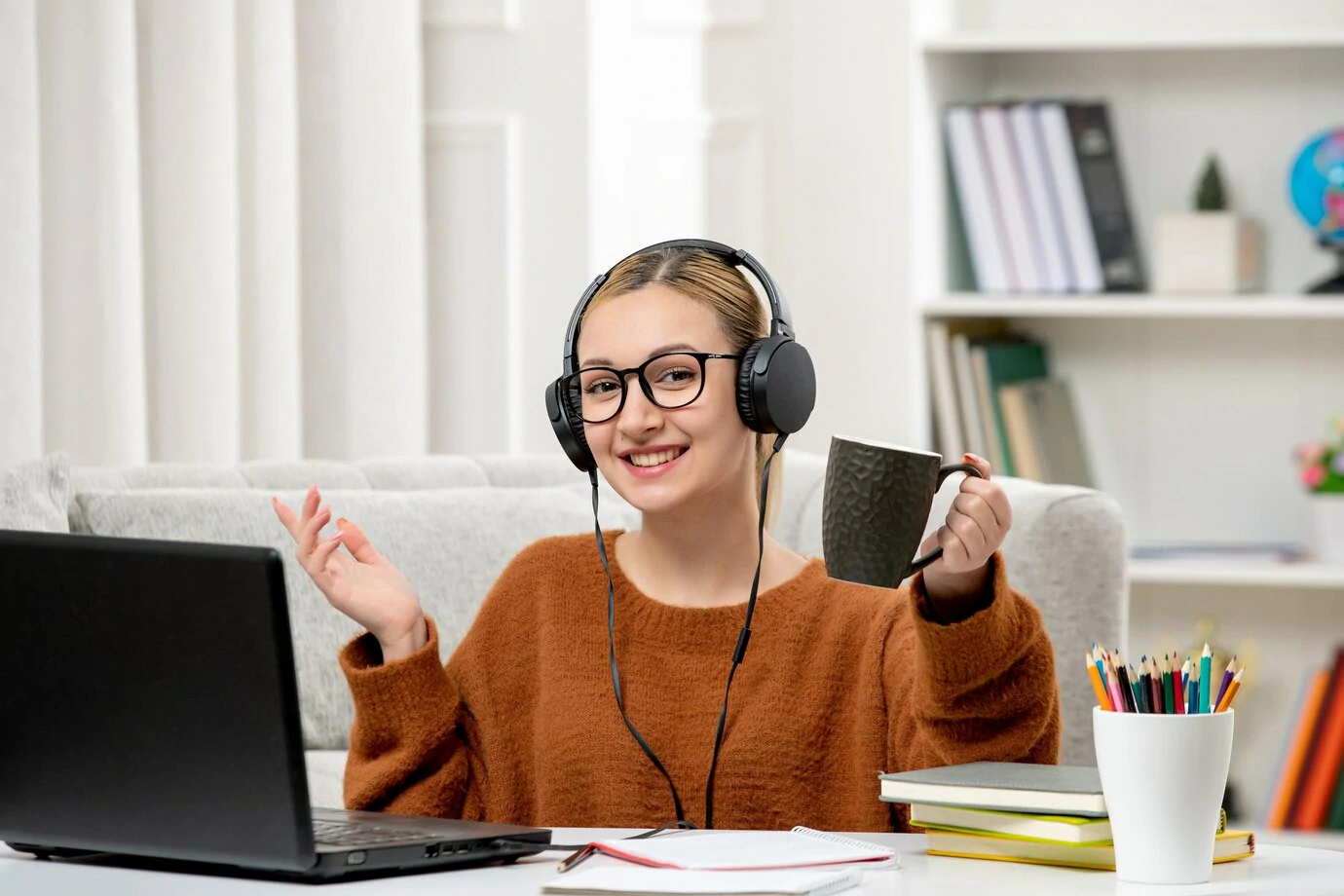 studying on computer holding a coffee cup